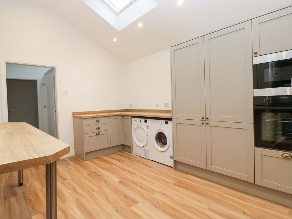 A kitchen with washing machine and dryer at New Barn Conversion Sedbergh