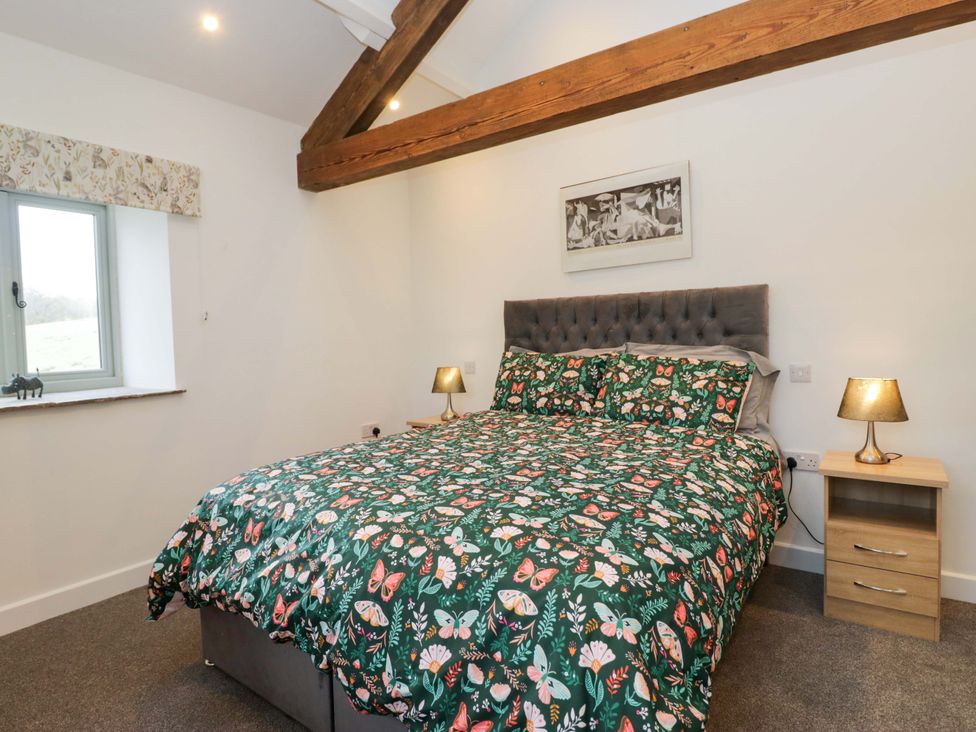 A bedroom with a bed and nightstand at New Barn Conversion in Sedbergh