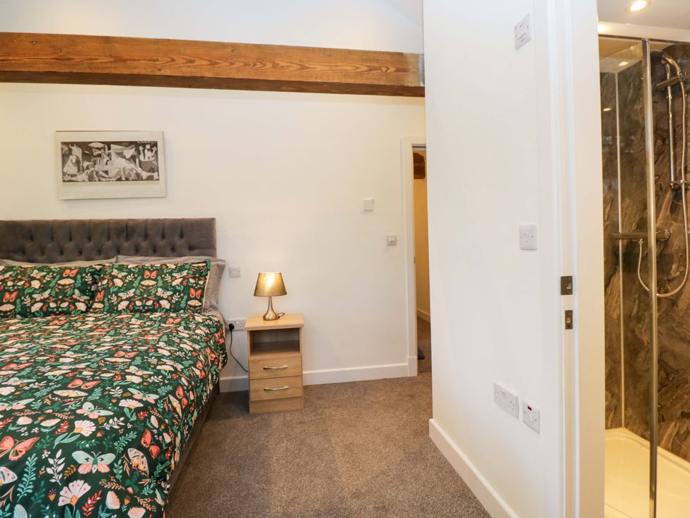 A bedroom with a bed and shower at New Barn Conversion in Sedbergh