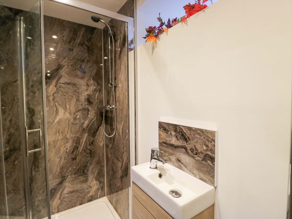 A bathroom with a shower and sink at New Barn Conversion Sedbergh