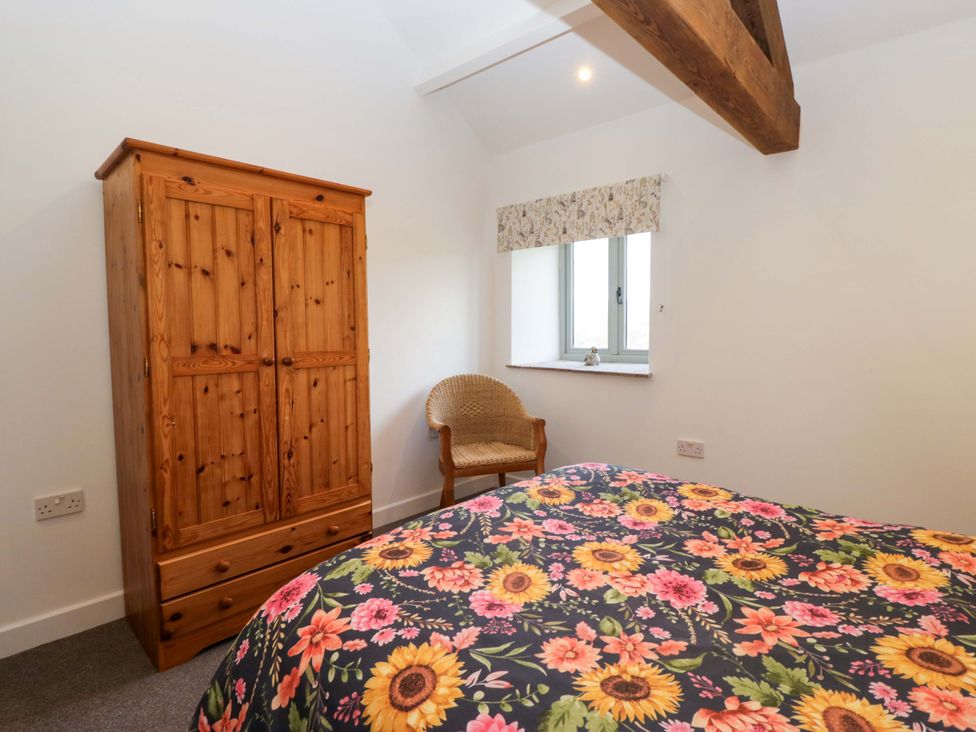 A bedroom with a bed and wardrobe at New Barn Conversion in Sedbergh