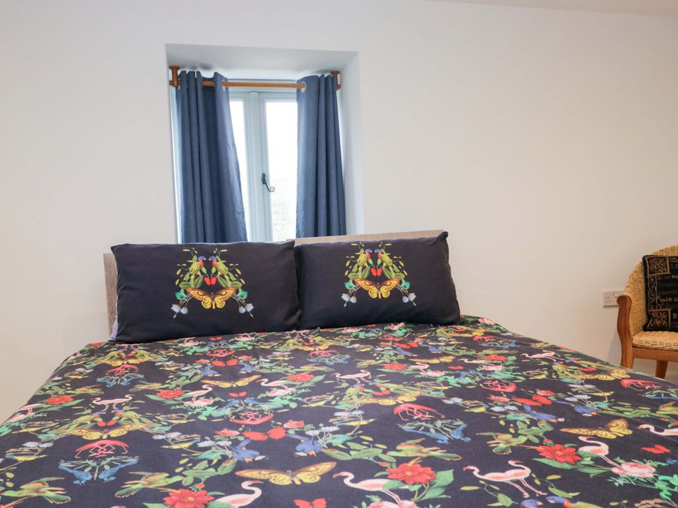 A bedroom with a bed and window at New Barn Conversion in Sedbergh