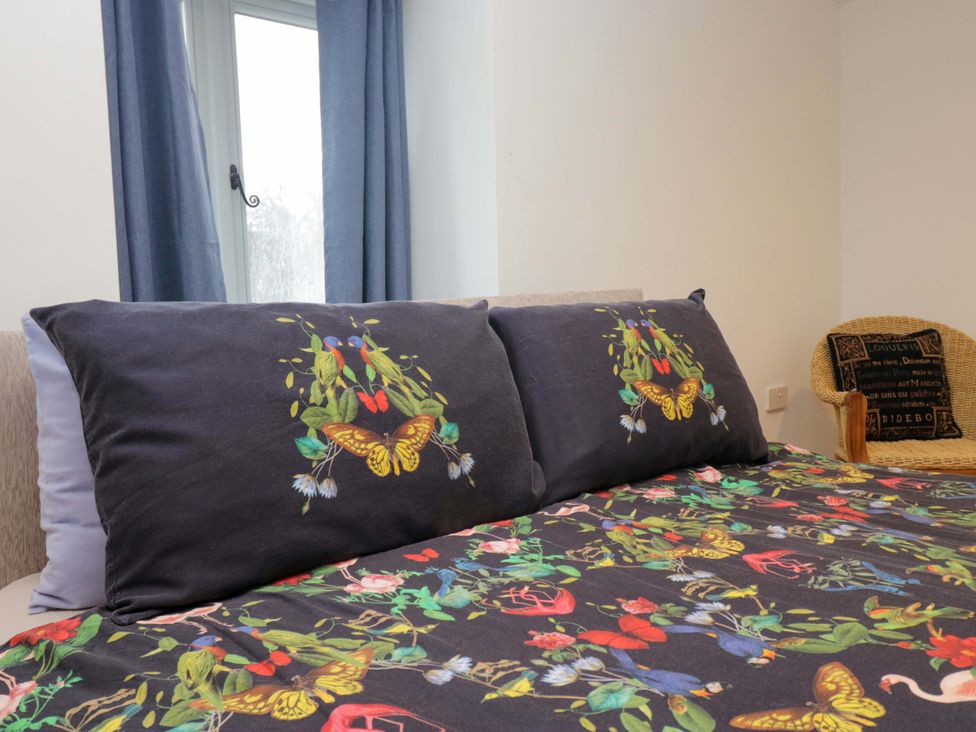 A bedroom with decorative pillows and a chair at New Barn Conversion Sedbergh