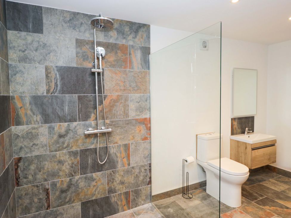 A bathroom with a shower and toilet at New Barn Conversion in Sedbergh