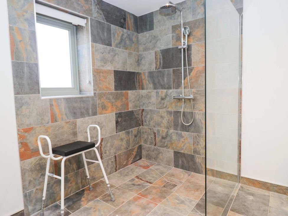 A bathroom with shower and stool at New Barn Conversion Sedbergh