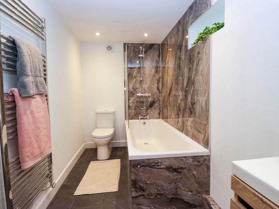 A bathroom with a bathtub and toilet at New Barn Conversion Sedbergh