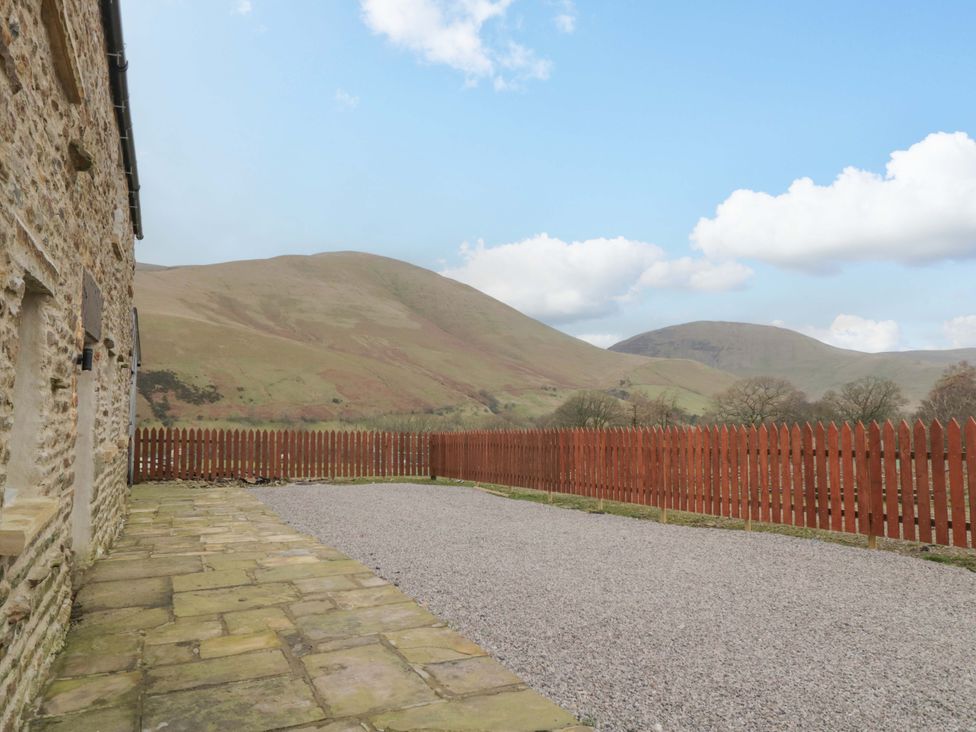 An outdoor space with gravel and a wooden fence at New Barn Conversion in Sedbergh