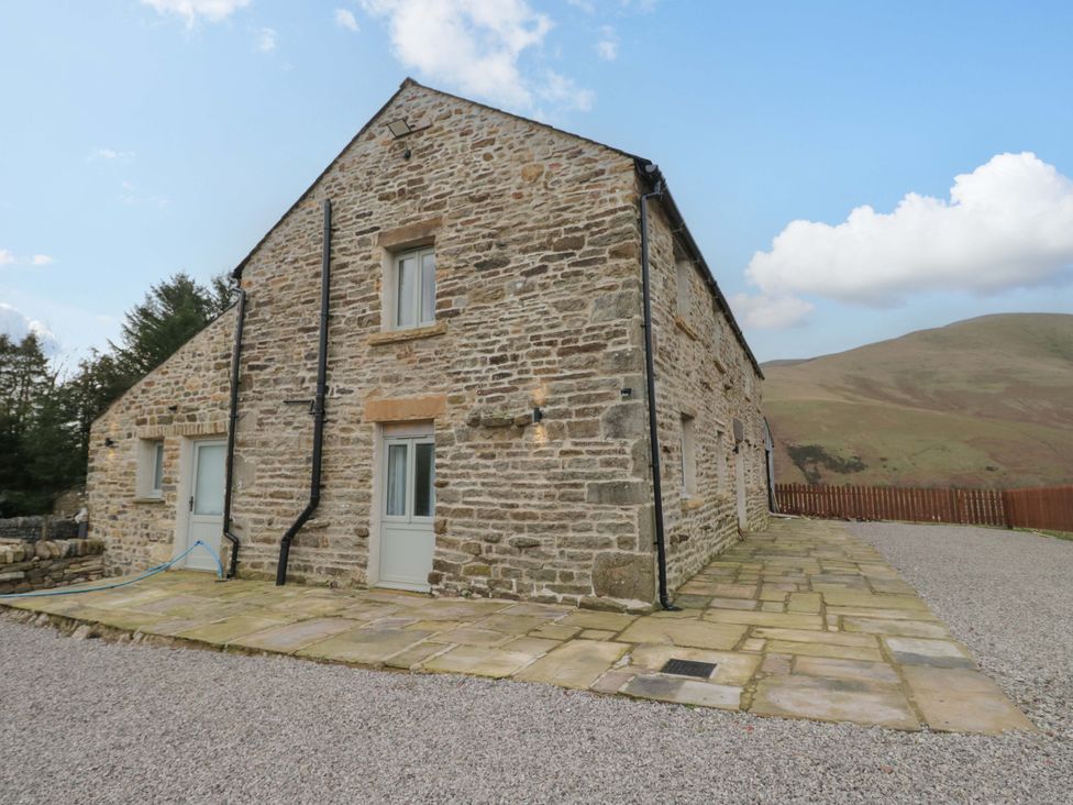 A stone house with windows and doors on a patio at New Barn Conversion Sedbergh