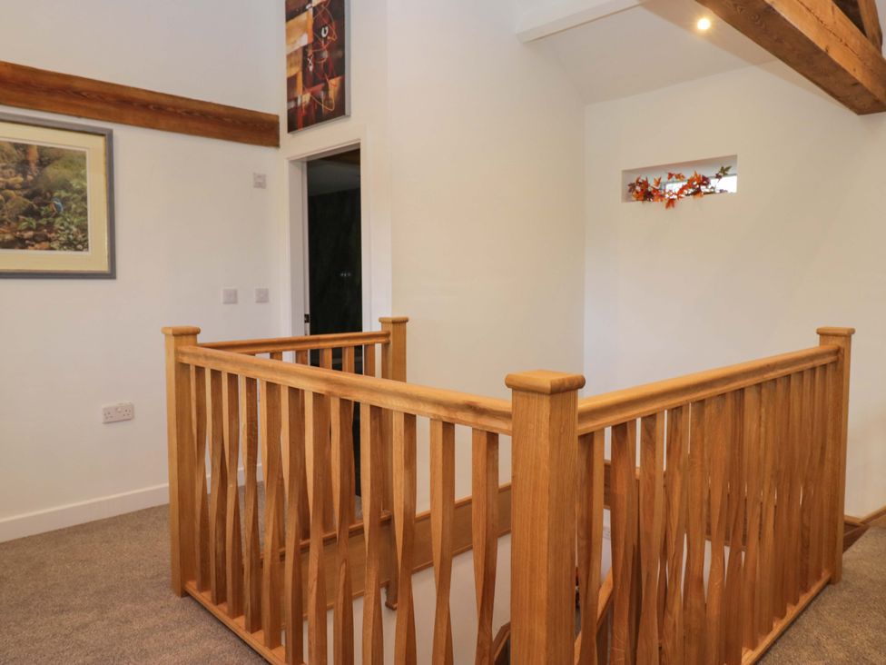 A landing with wooden railing and door at High Birks Barn Cautley near Sedbergh
