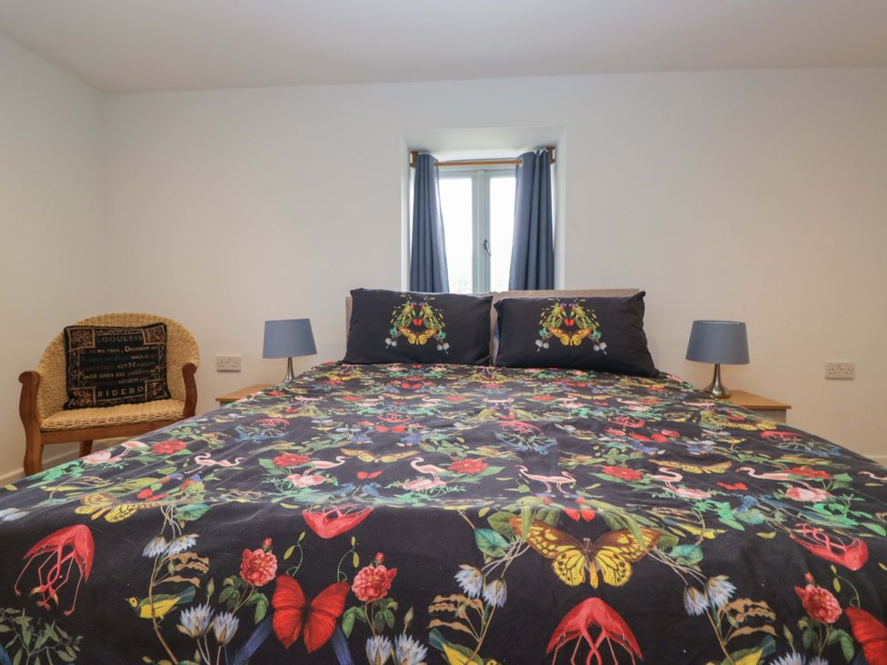A bedroom with a bed and a chair at High Birks Barn Cautley near Sedbergh