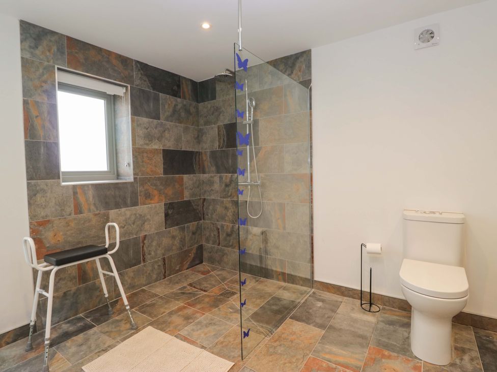 A bathroom with a shower and toilet at High Birks Barn in Cautley near Sedbergh