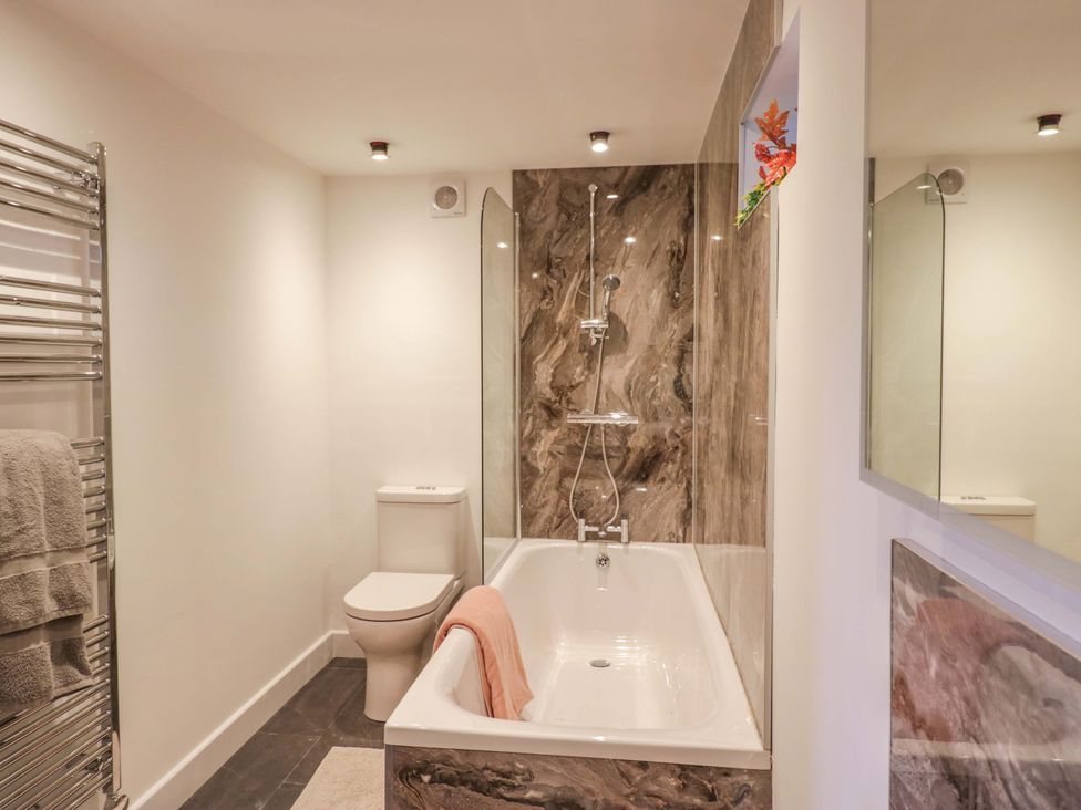 A bathroom with a bathtub and shower at High Birks Barn Cautley near Sedbergh