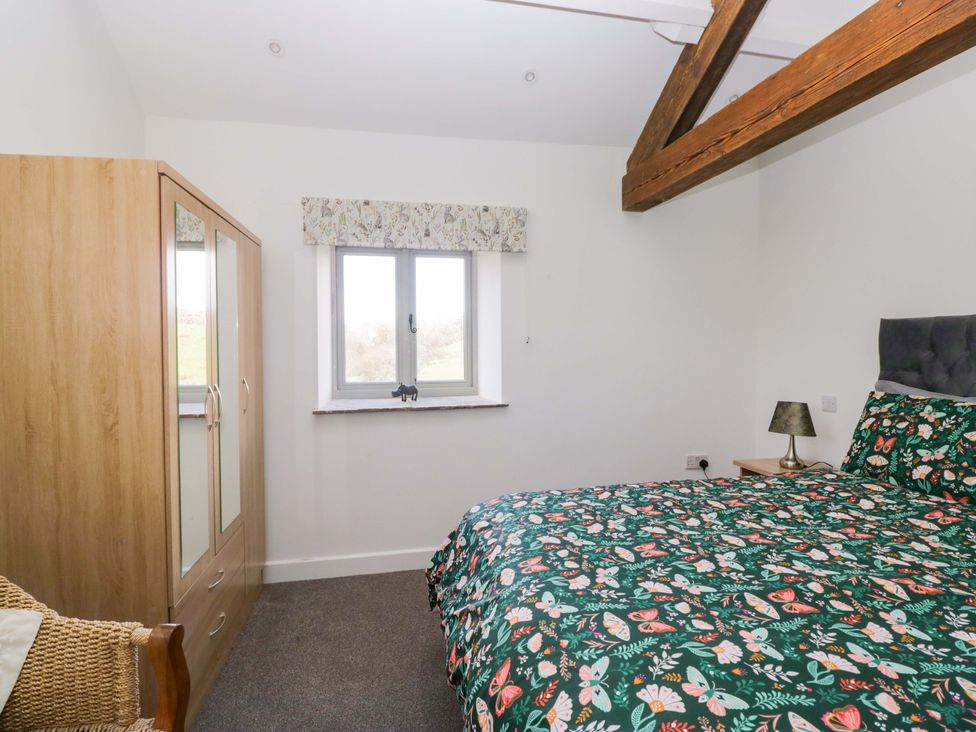 A bedroom with a bed and wardrobe at High Birks Barn Cautley near Sedbergh