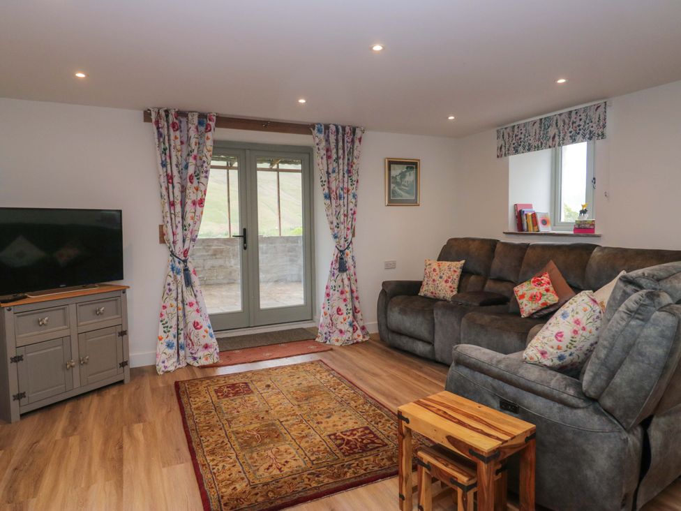 A living room with a sofa and television at High Birks Barn Cautley near Sedbergh