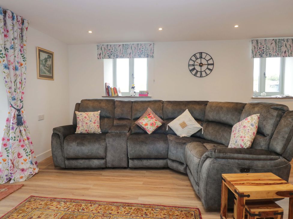 A living room with a sofa and cushions at High Birks Barn Cautley near Sedbergh