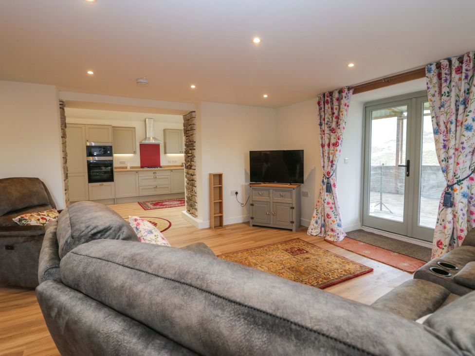 A living room with a sofa and television at High Birks Barn Cautley near Sedbergh