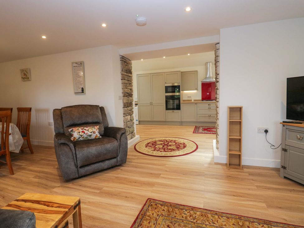 A living room with a chair and dining table at High Birks Barn Cautley near Sedbergh