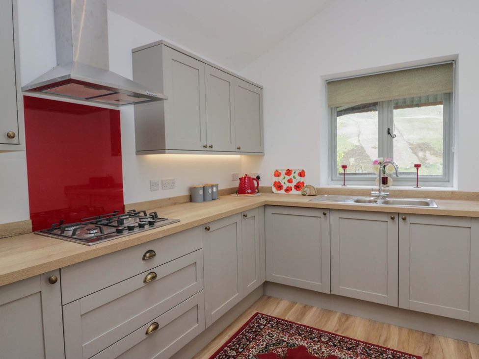 A kitchen with cabinets and a stove at High Birks Barn, Cautley near Sedbergh