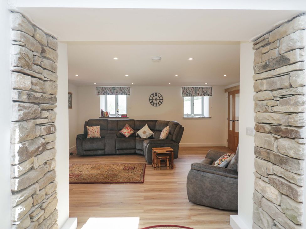 A living room with a sofa and armchair at High Birks Barn Cautley near Sedbergh