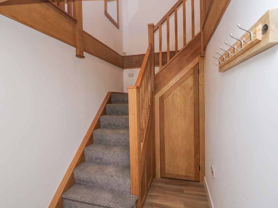 A hallway with stairs and coat hooks at High Birks Barn in Cautley near Sedbergh