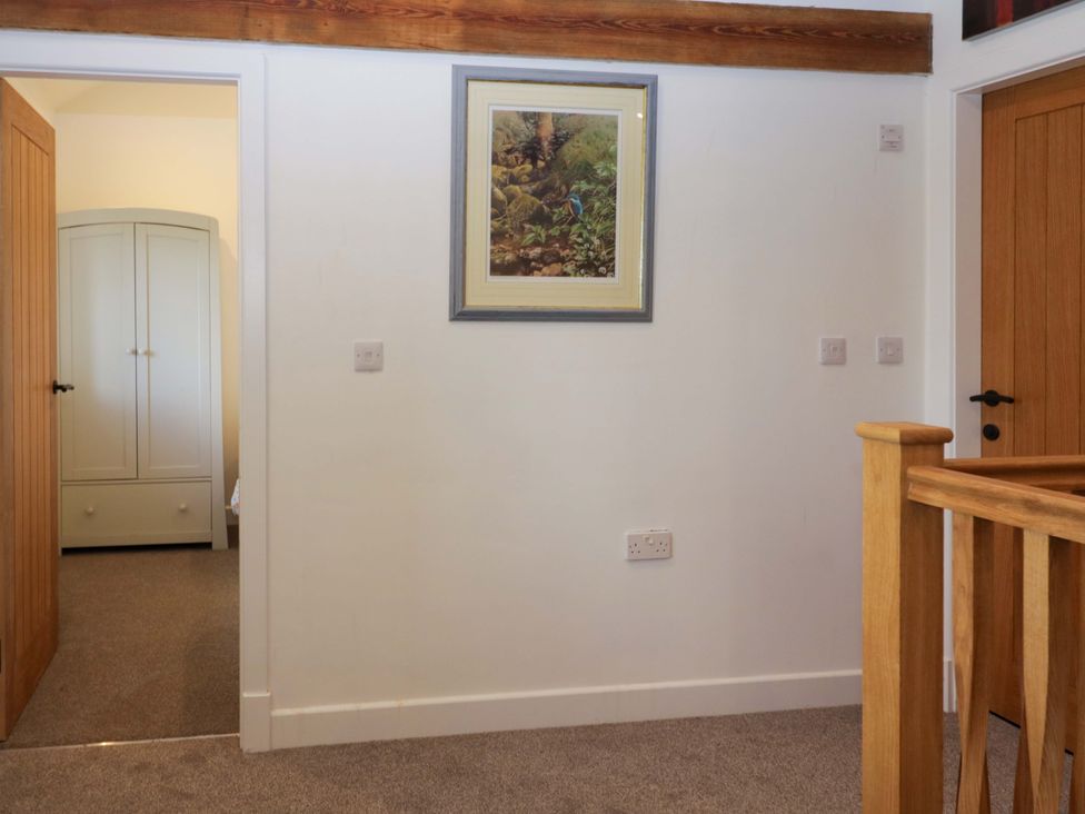 A hallway with a wardrobe and a painting at High Birks Barn in Cautley near Sedbergh
