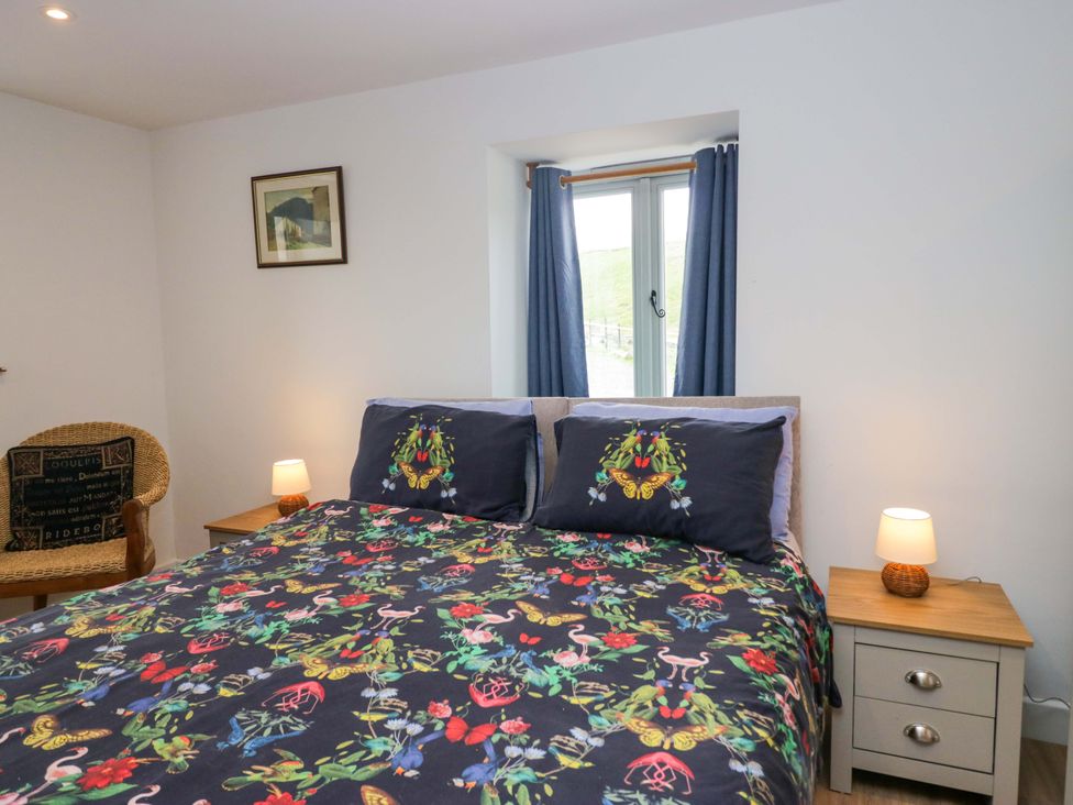 A bedroom with a bed and side table at High Birks Barn Cautley near Sedbergh