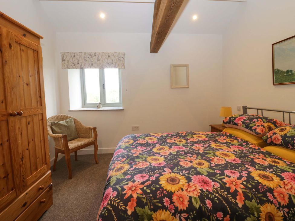 A bedroom with a bed and wardrobe at High Birks Barn in Cautley near Sedbergh