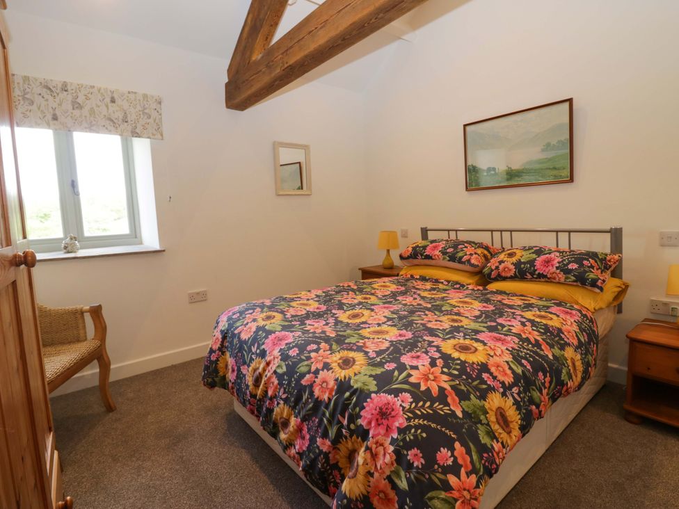 A bedroom with a bed and a chair at High Birks Barn Cautley near Sedbergh