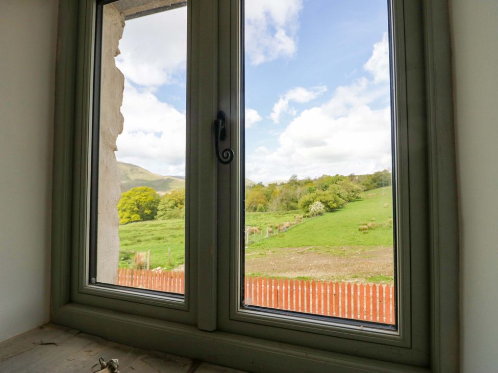 A view of trees and grass through a window at High Birks Barn Cautley near Sedbergh