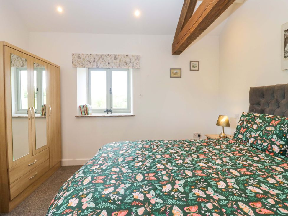 A bedroom with a bed and wardrobe at High Birks Barn Cautley near Sedbergh
