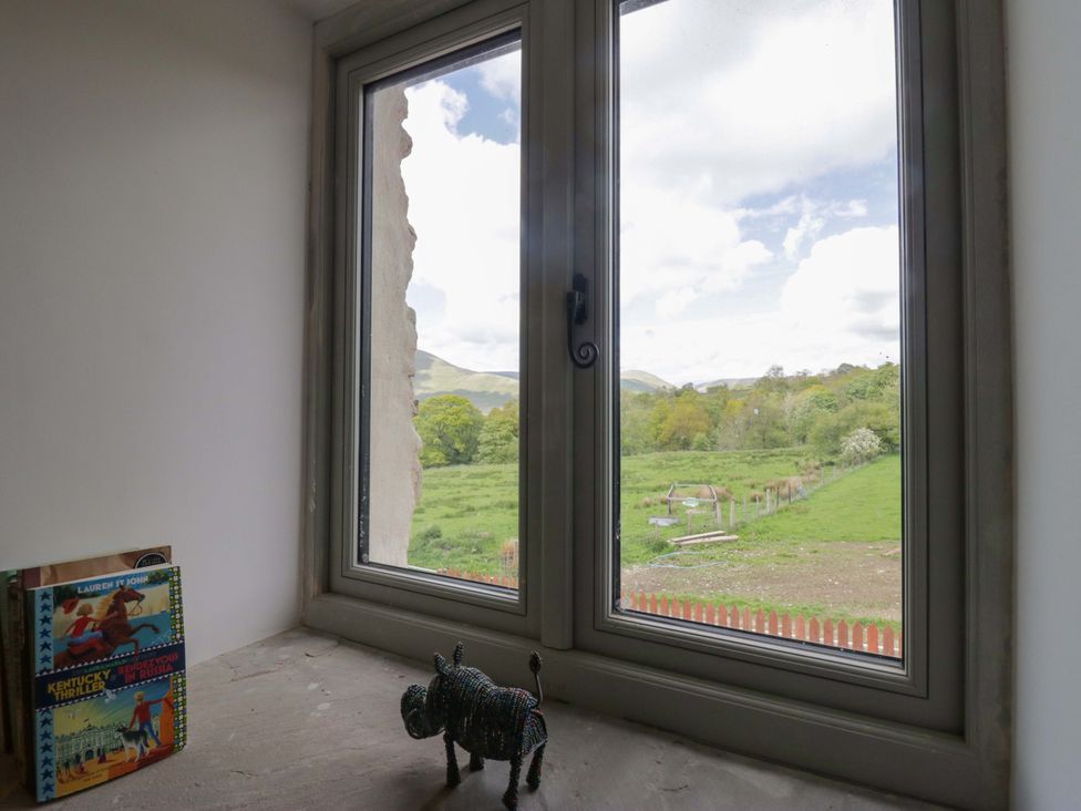 A room with a window overlooking green fields at High Birks Barn in Cautley near Sedbergh