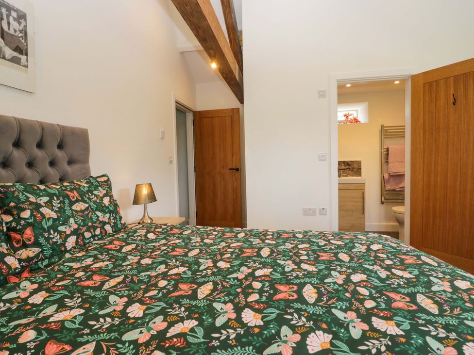 A bedroom with a bed and entrance to a bathroom at High Birks Barn Cautley near Sedbergh