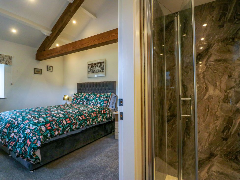 A bedroom with a bed and shower at High Birks Barn Cautley near Sedbergh