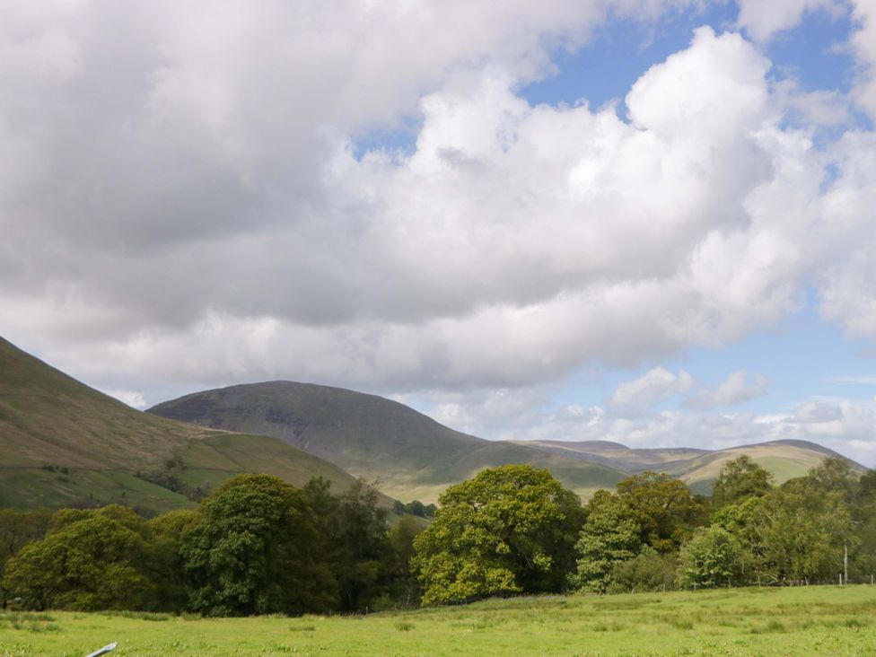A landscape view with mountains and trees at High Birks Barn in Cautley near Sedbergh