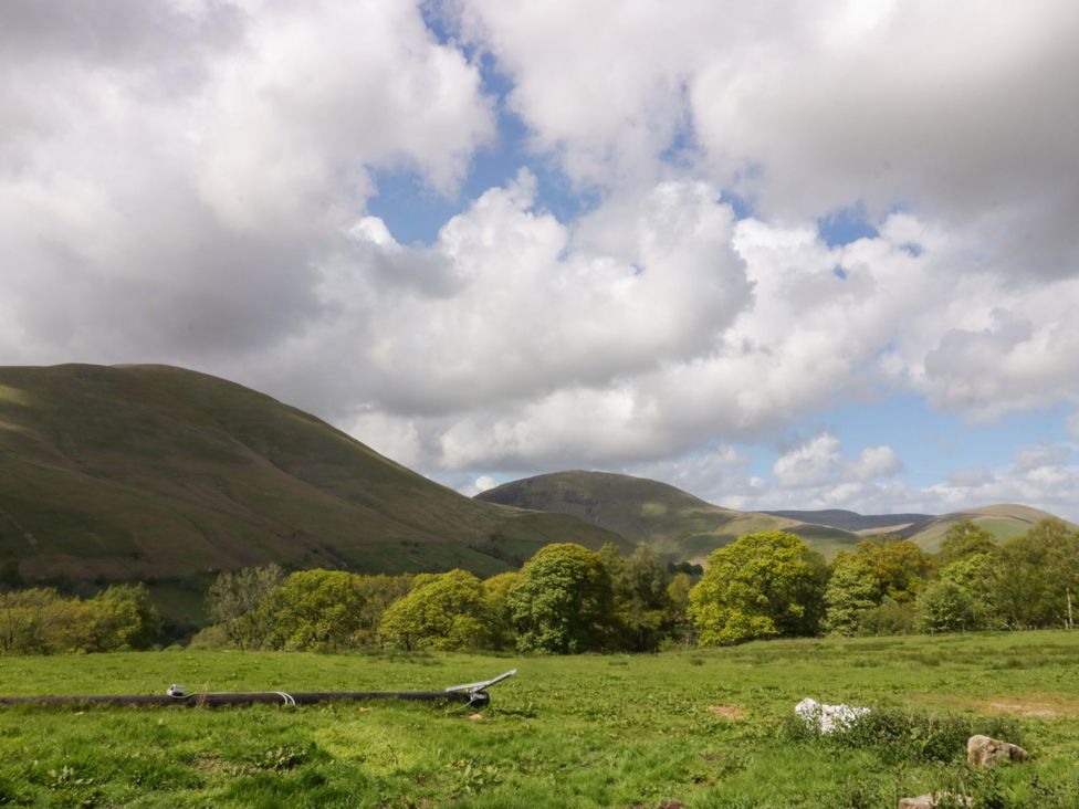 A view of hills and trees in a field at High Birks Barn Cautley near Sedbergh