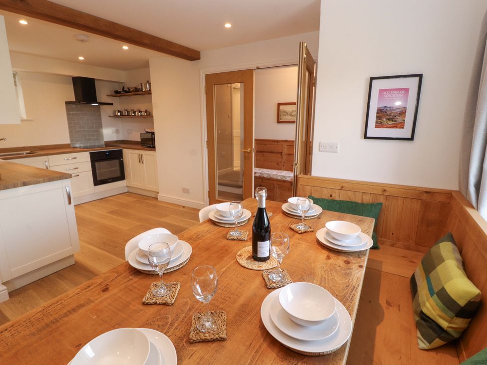 A dining area with table and wine bottles at Bramble Cottage Thornthwaite near Braithwaite