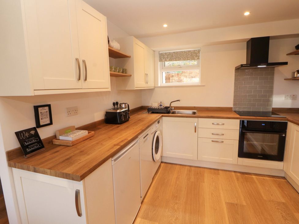 A kitchen with cabinets and appliances at Bramble Cottage in Thornthwaite near Braithwaite