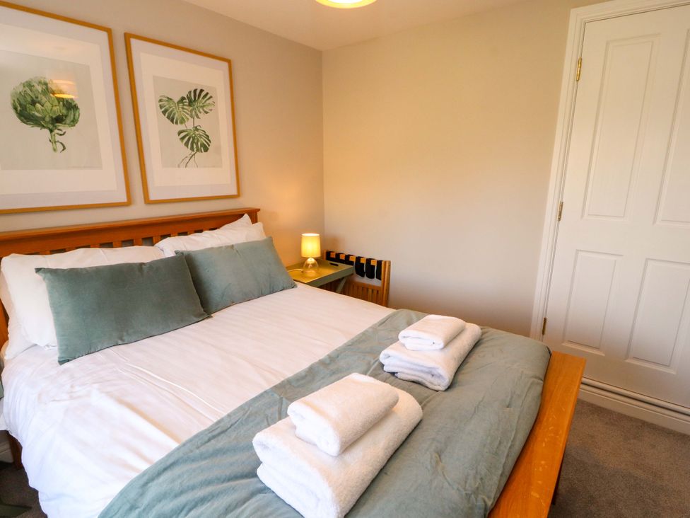 A bedroom with a bed and artwork on the wall at Bramble Cottage Thornthwaite near Braithwaite