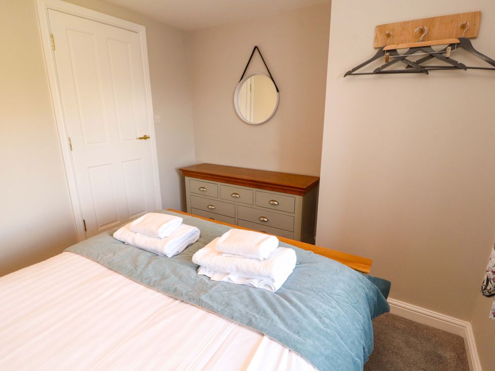 A bedroom with a bed and towels on top at Bramble Cottage Thornthwaite near Braithwaite