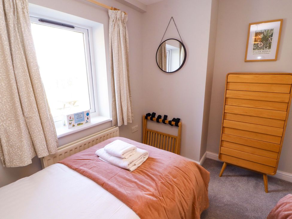 A bedroom with a bed and window at Bramble Cottage in Thornthwaite near Braithwaite