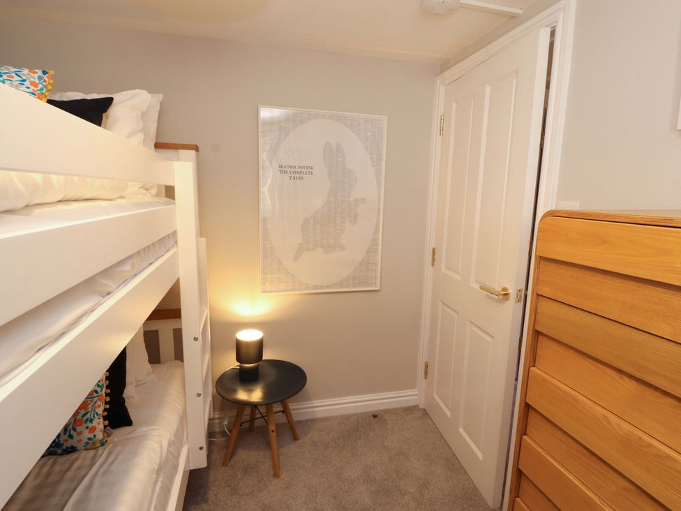 A bedroom with bunk bed and poster at Bramble Cottage in Thornthwaite near Braithwaite