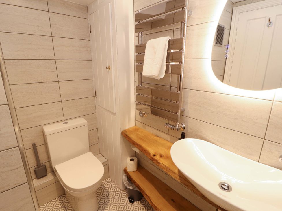 A bathroom with a toilet and sink at Bramble Cottage Thornthwaite near Braithwaite