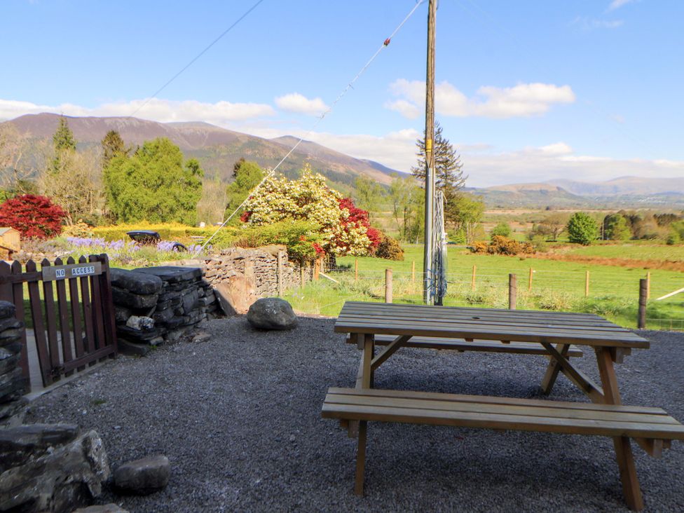An outdoor area with a picnic table and mountain view at Bramble Cottage Thornthwaite near Braithwaite