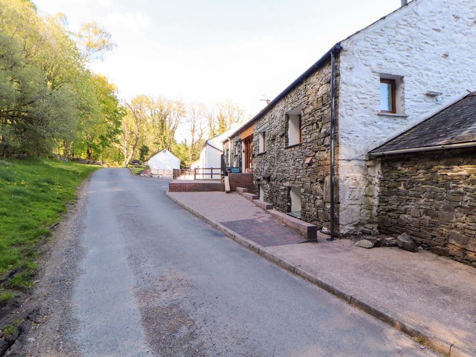 A stone building with steps near a road at Bramble Cottage Thornthwaite near Braithwaite