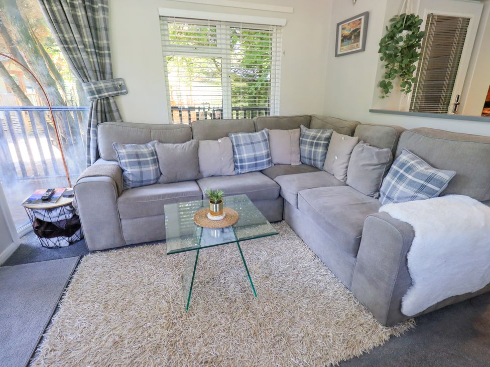 A living room with a sofa and coffee table at Evermore Lodge, 48 Calgarth Park, White Cross Bay, Windermere