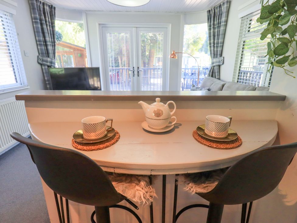 A dining area with a table set for tea at Evermore Lodge, 48 Calgarth Park, White Cross Bay, Windermere