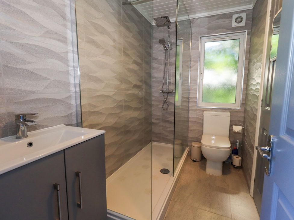 A bathroom with a shower, toilet, and sink at Evermore Lodge, 48 Calgarth Park, White Cross Bay, Windermere
