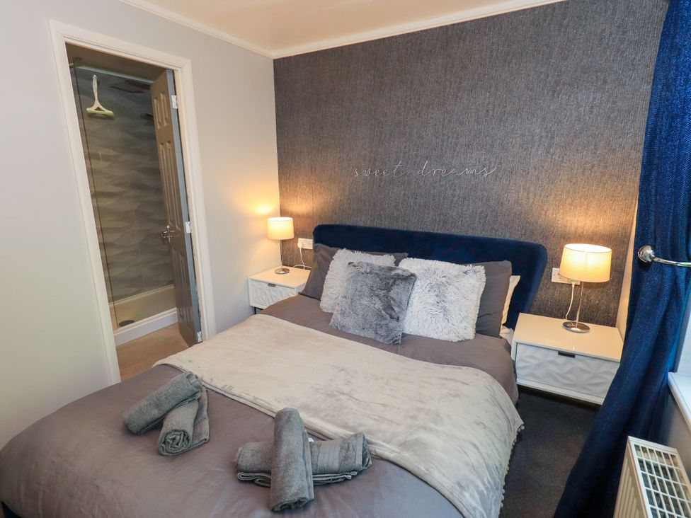 A bedroom with a bed and nightstand at Evermore Lodge, 48 Calgarth Park, White Cross Bay, Windermere