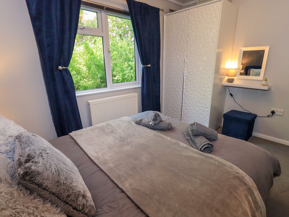 A bedroom with a bed and wardrobe at Evermore Lodge, 48 Calgarth Park, White Cross Bay, Windermere