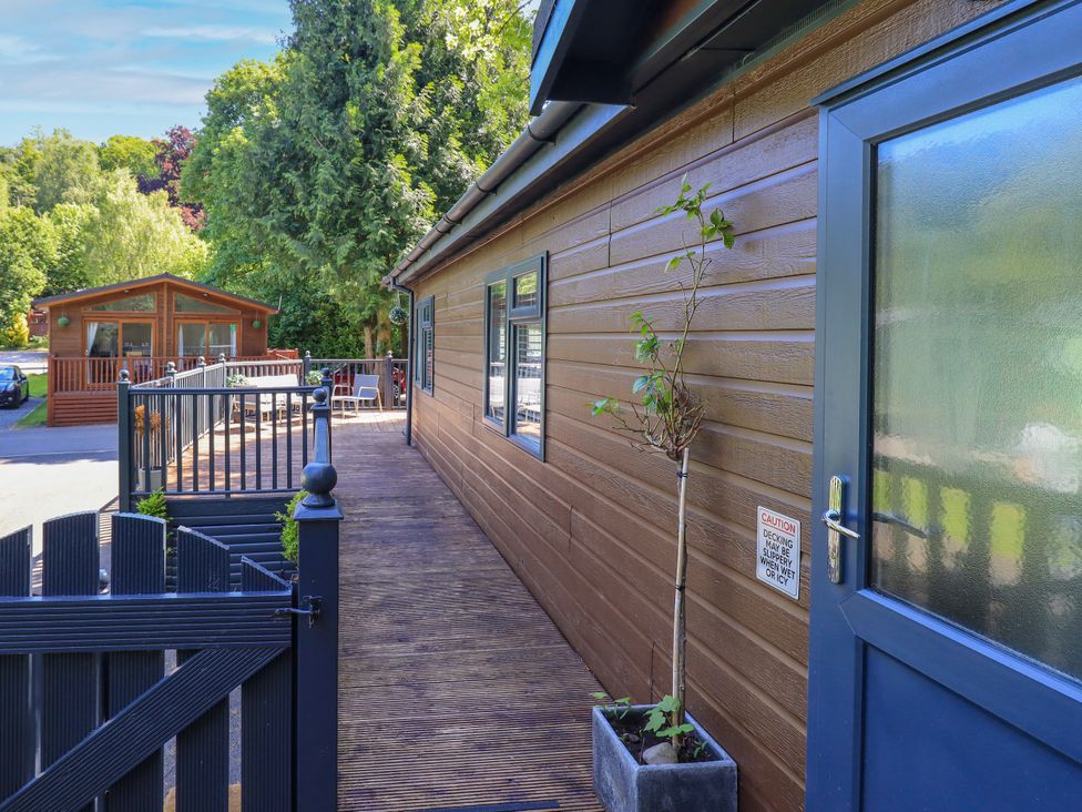 An outdoor area with wooden decking and a cabin at Evermore Lodge, 48 Calgarth Park, White Cross Bay, Windermere